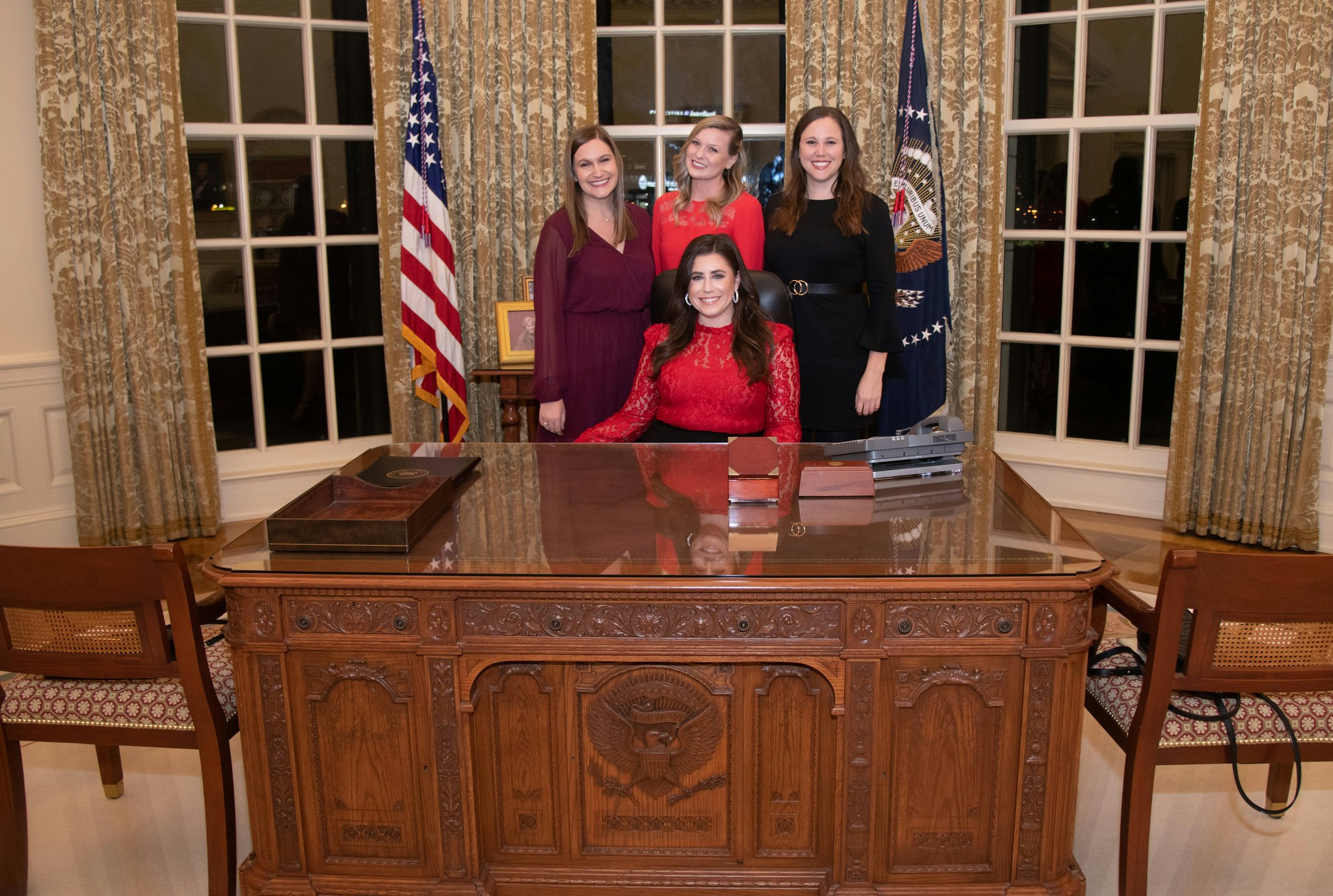 Four ladies sitting at the replica desk in the permanent exhibit.